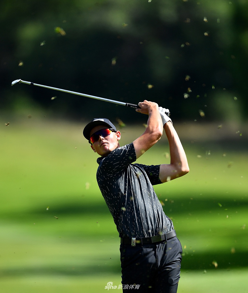 亚伦-科克里尔在沙坑中全力一击，沙粒飞扬，他首轮表现优异，高居并列第三位。