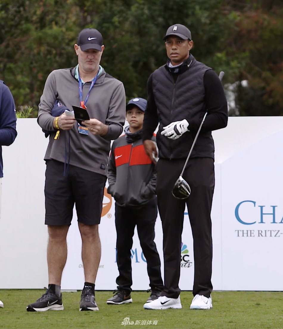 查理·伍兹仔细研究果岭线路，父亲站在身后默默关注，信任与成长在此刻交织。