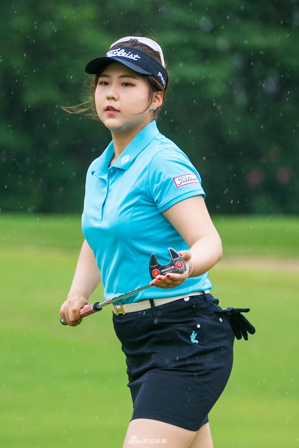 李睿璱开球后自信眺望球路，蓝天绿草间尽显飒爽英姿