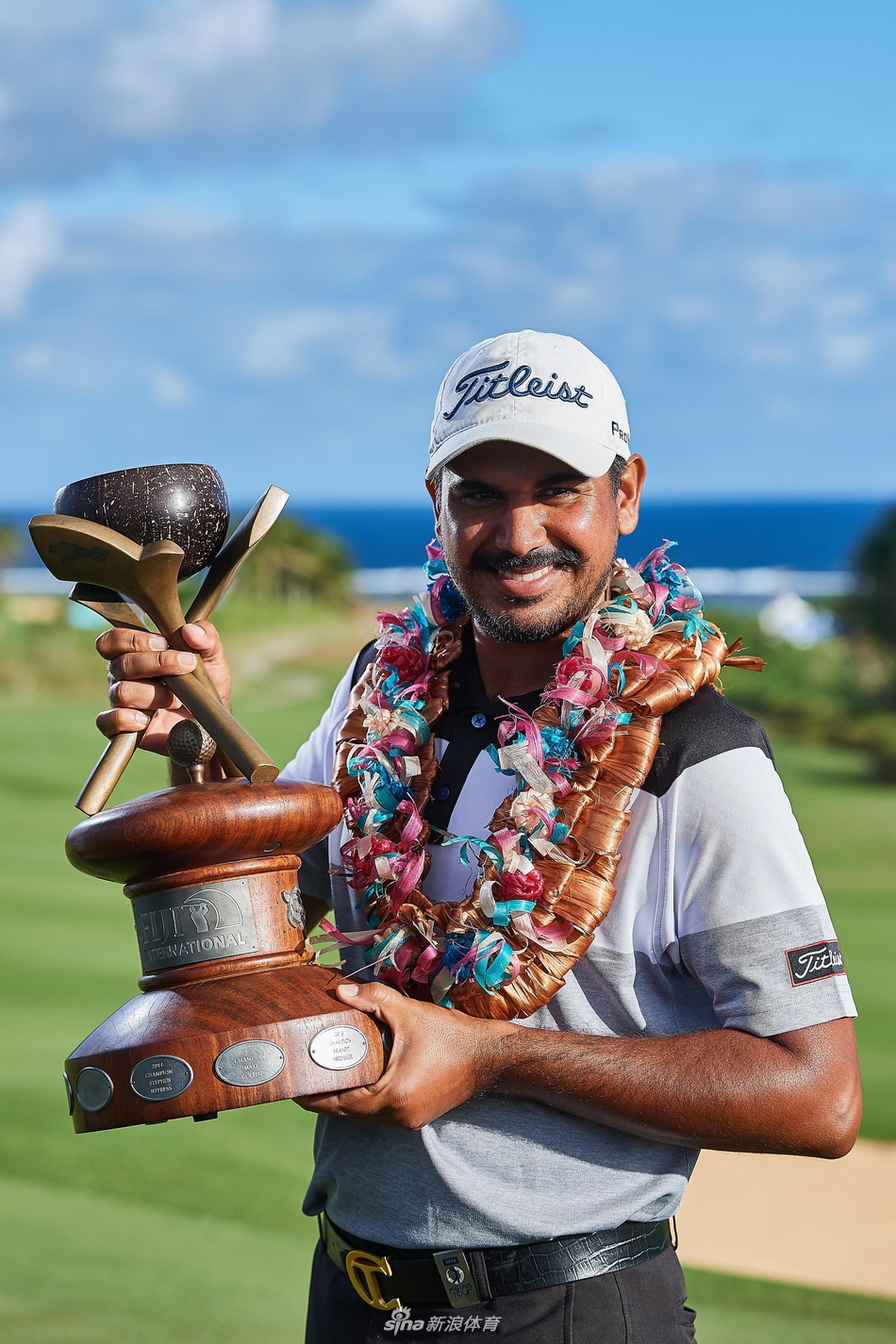 南非高尔夫名将埃尔斯正全神贯注地审视果岭起伏，他半蹲的身姿与远处辽阔的海岸线构成一幅充满张力与智慧的画卷