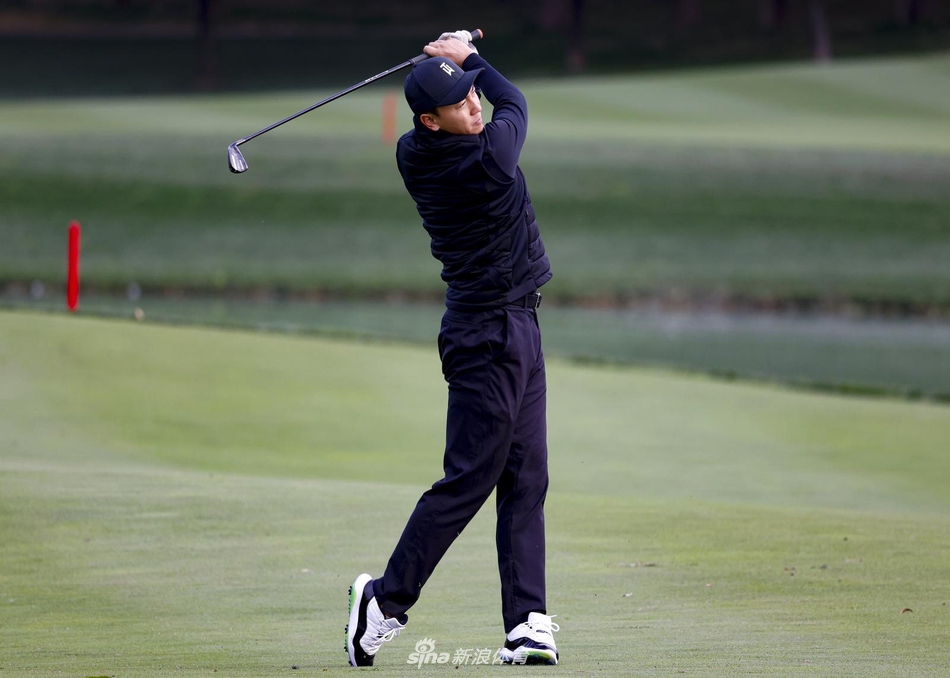 释小龙完成一组推杆后，从容地将球杆收回，动作干净利落，脸上带着满足而平静的微笑，享受运动后的舒畅。