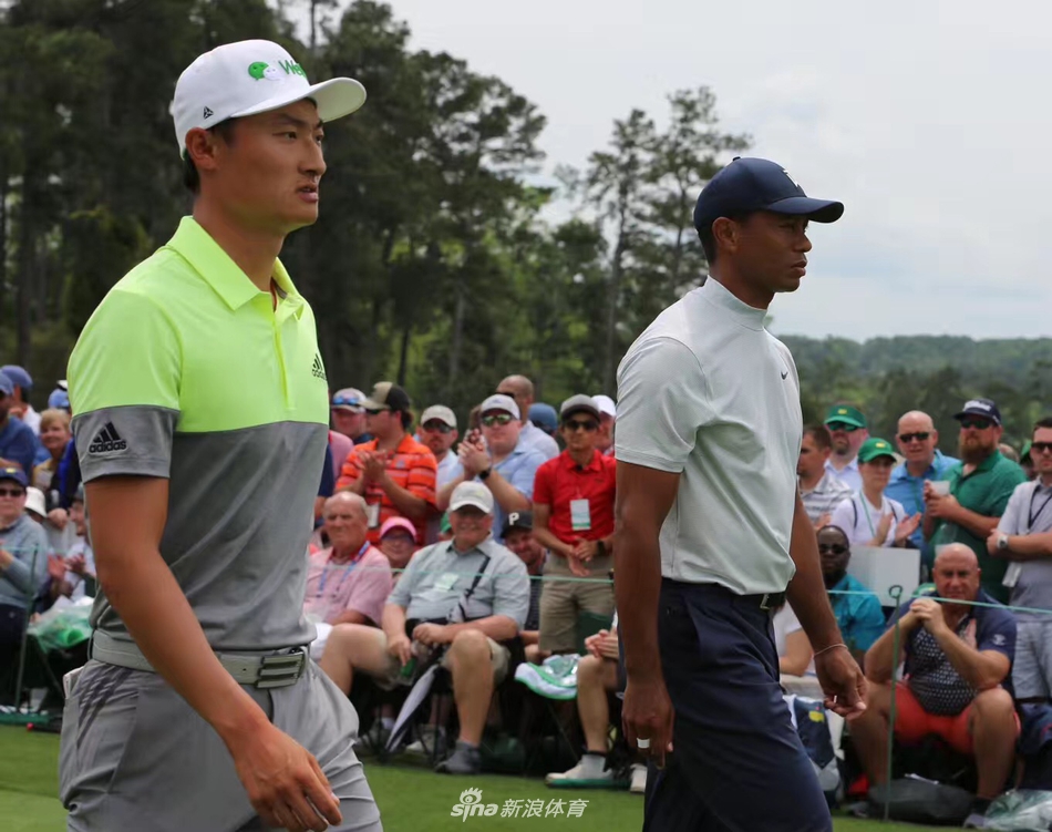 老虎伍兹侧身站立，在球道沙坑旁凝神思考，经典的挥杆预备姿势充满力量感与艺术性。