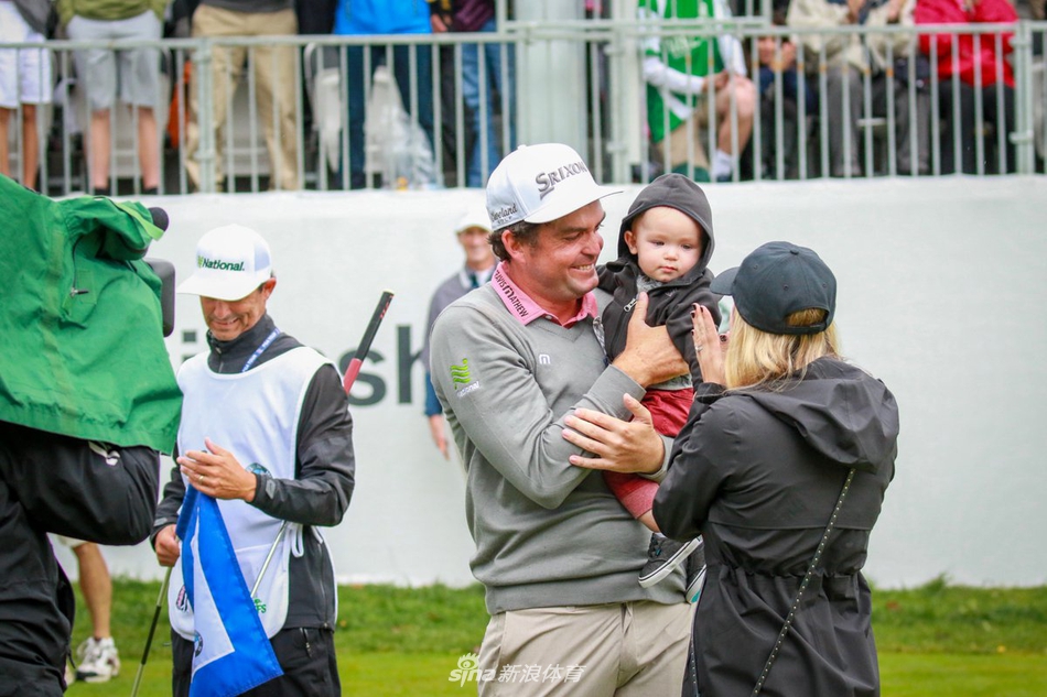 布拉德利深情亲吻妻子，妻子闭眼微笑，两人之间洋溢着历经风雨后共享成功的无间亲密与巨大幸福。