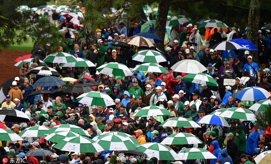 一位穿着传统绿夹克的赛事工作人员手持对讲机站在路口，背景里层层叠叠的彩色雨伞形成了一个梦幻般的通道，传统与现代、秩序与欢愉在此刻和谐共存。