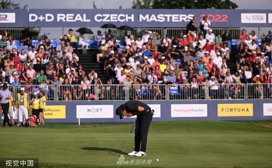 白政恺在沙坑中优雅挥杆救球，沙粒如金色瀑布般扬起，勾勒出运动员精湛的短杆技术与从容姿态