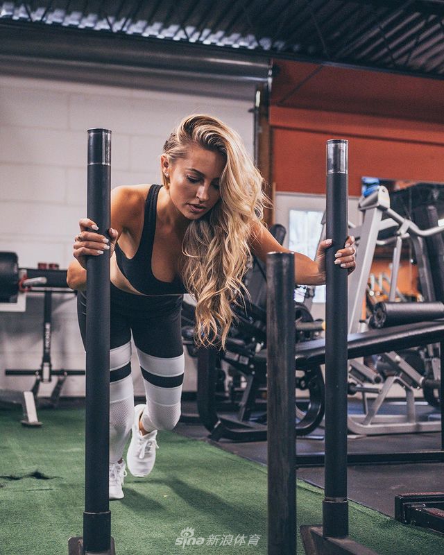 妮基独自站立在果岭旁，温柔注视场上比赛的坎特利，神情专注而充满支持。