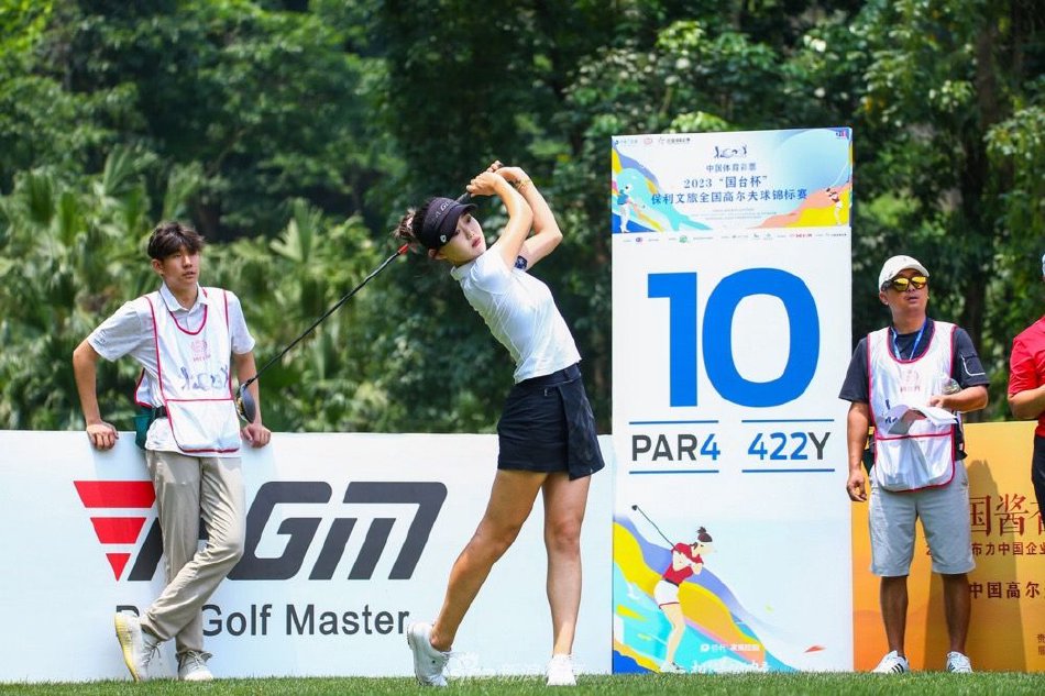 一位球员在开阔的练习场奋力挥杆，白色小球划破天际，瞬间凝聚了力量、技巧与对胜利的渴望