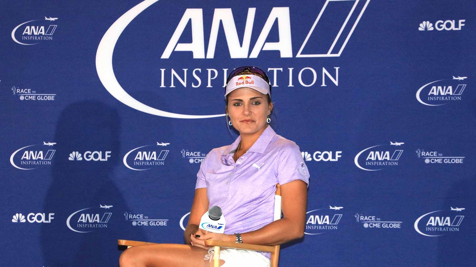 高尔夫球星莱克西·汤普森在聚光灯下进行推杆示范，动作流畅优雅，周围观众投来欣赏的目光。