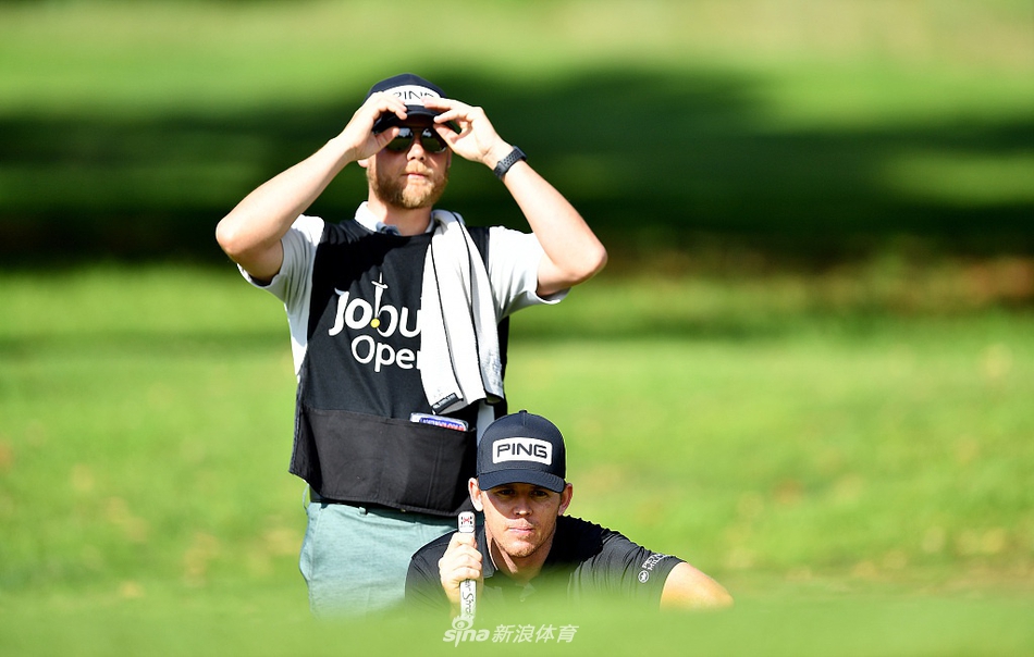 肖恩-诺里斯在果岭边冷静观察推杆线路，他首轮比赛表现稳健，没有吞下任何一个柏忌。