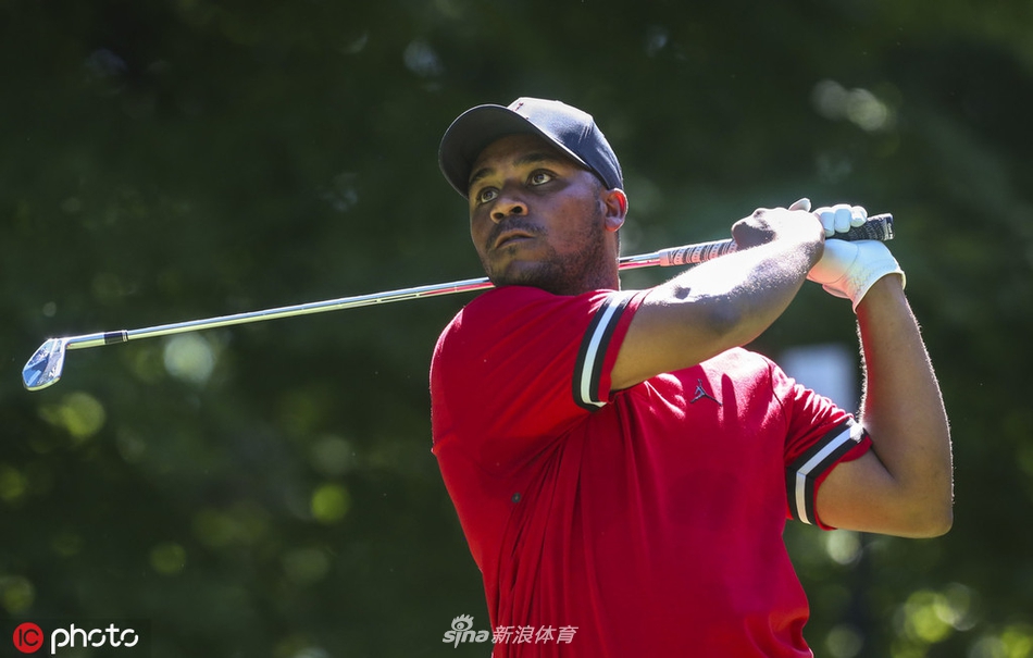 强鹿精英赛赛场边的赞助商标识与观众看台，展现了现代职业高尔夫赛事商业与体育的完美结合。