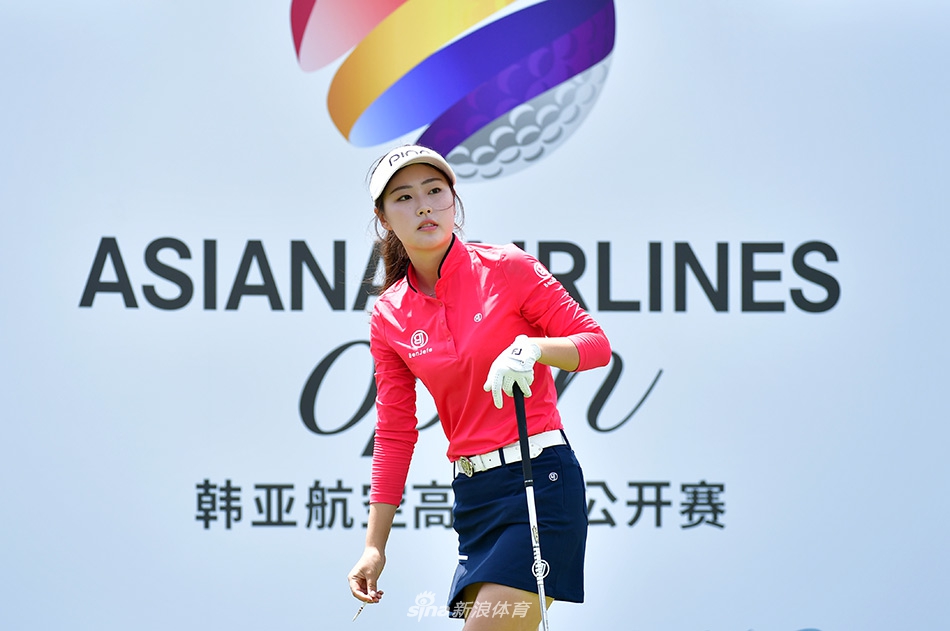 金旼宣在球道上稳健进攻，果岭旗帜在海风中飘扬，背景是辽阔海面