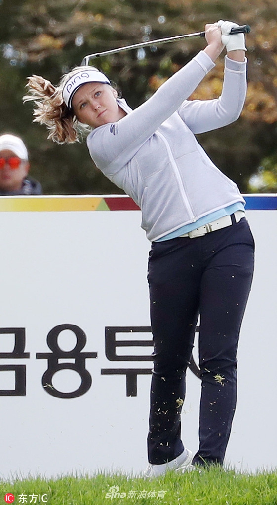 查莉·赫尔在比赛中观察果岭，她需要为下一推仔细评估草纹与坡度。