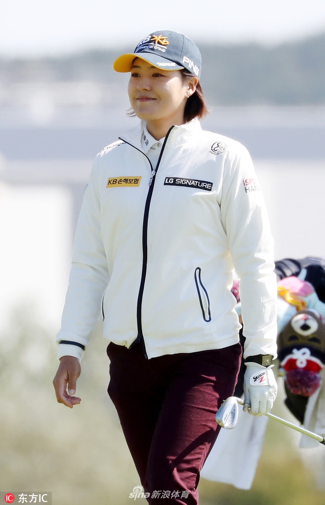 田仁智在果岭边进行精细的切杆，表情认真，姿势标准，力求将球送到洞杯附近。