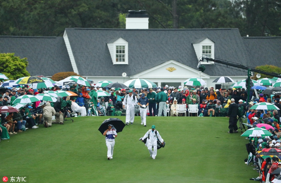俯瞰视角下，蜿蜒的球道犹如一条翡翠色绸带，两旁密密麻麻的彩色雨伞如同洒落在绿色天鹅绒上的宝石，璀璨夺目。