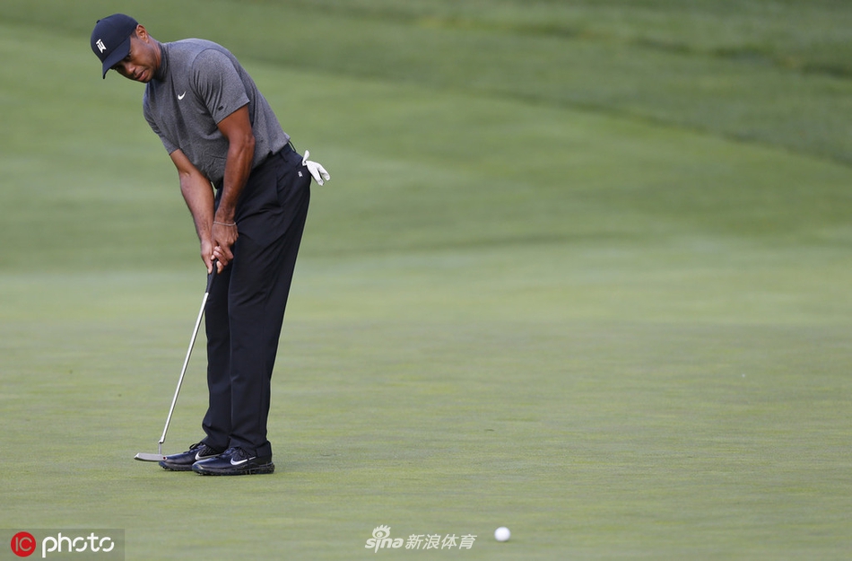 伍兹与球童在球道上并肩同行，认真讨论下一杆的策略，展现了对比赛每个细节的精密把控。