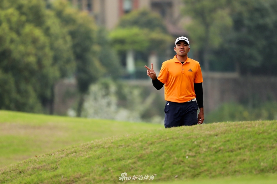 中国选手刘晏玮在果岭边半蹲观察推杆路线，神情专注地研究草纹与地形