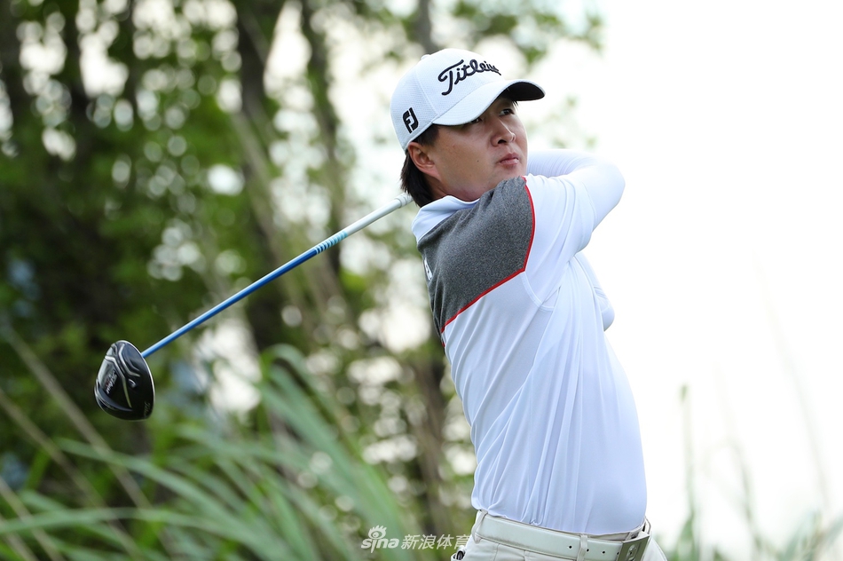 高尔夫球手在沙坑中调整姿势准备击球，沙粒在阳光下闪闪发光