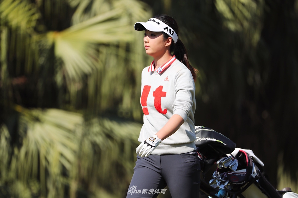 广州少年梁恩旗在果岭边沉稳观察推杆线路，目光专注如炬