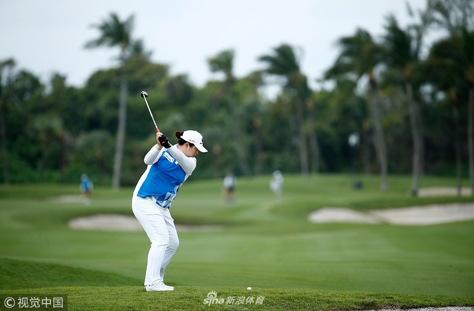 世界第一冯珊珊在巴哈马赛场上准备推杆，目光如炬，果岭上的草纹与她的专注神情构成了胜负世界的微观战场。