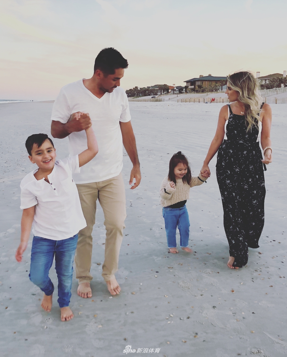 萌娃达什搞怪地抢过镜头焦点，戴伊夫妇在背景中无奈又幸福地笑着。