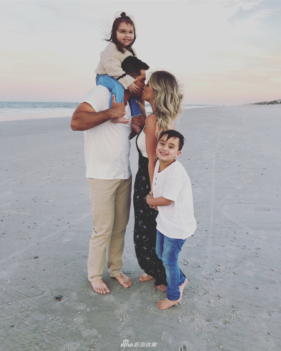 女儿露西俏皮地躲在妈妈身后探头张望，戴伊夫妇相视一笑，眼中满是宠溺。