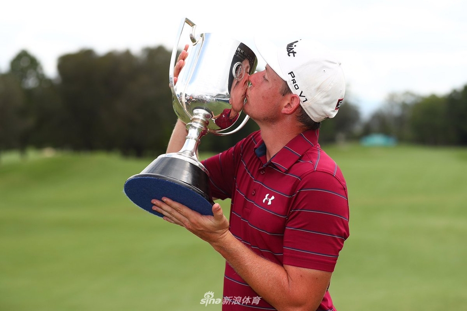 经过两洞加赛的漫长煎熬，史密斯凝视着象征冠军的奖杯，眼中闪烁着梦想成真的光芒。