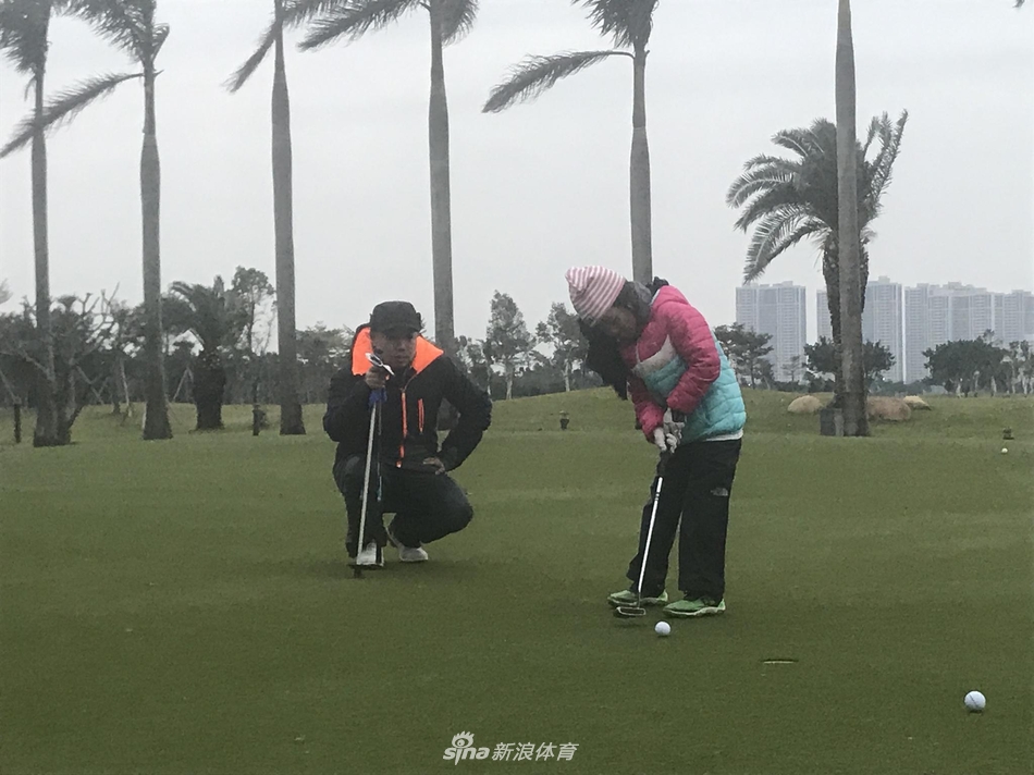 刘国梁手持果岭叉,亲自为女儿在果岭上标记高尔夫球的位置,每一个细节都体现着专业与关爱