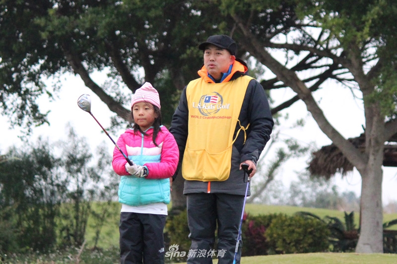 刘国梁蹲在果岭边,全神贯注地指导女儿刘宇婕推杆,父女二人的身影在绿茵场上构成一幅温馨而专注的画面