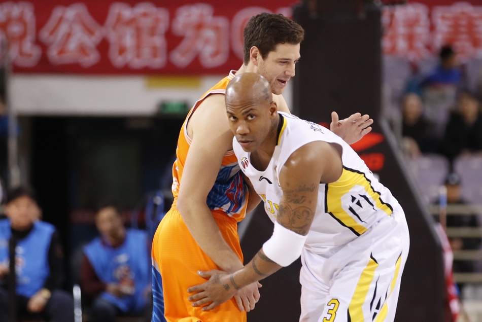 兰多夫迎着上海队中锋张兆旭的长臂，依然强硬地将球放入篮筐，肌肉的碰撞声仿佛穿透了图片，让人感受到内线搏杀的残酷。