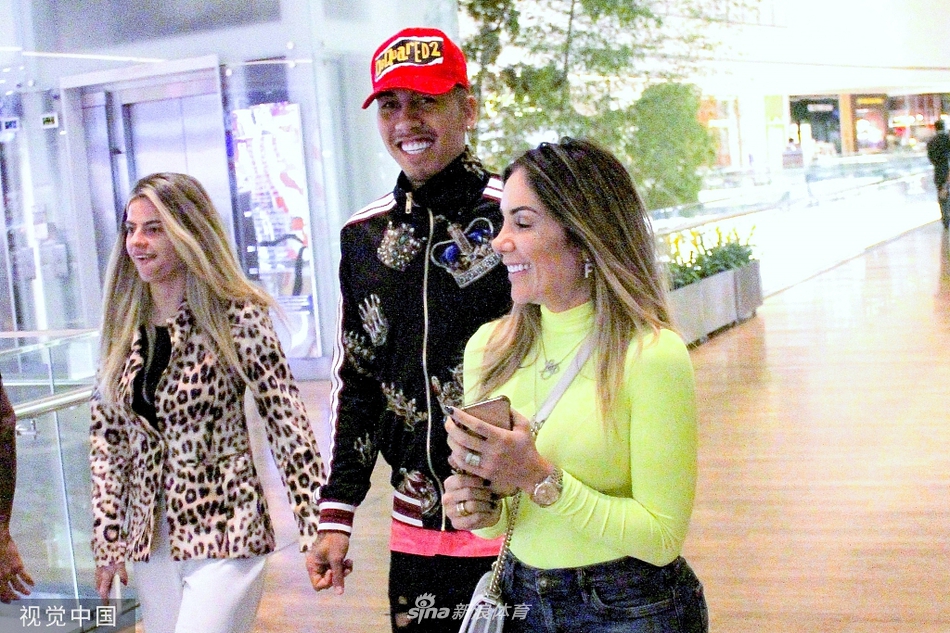 菲尔米诺在商店内专注挑选商品，身旁女子微笑陪伴