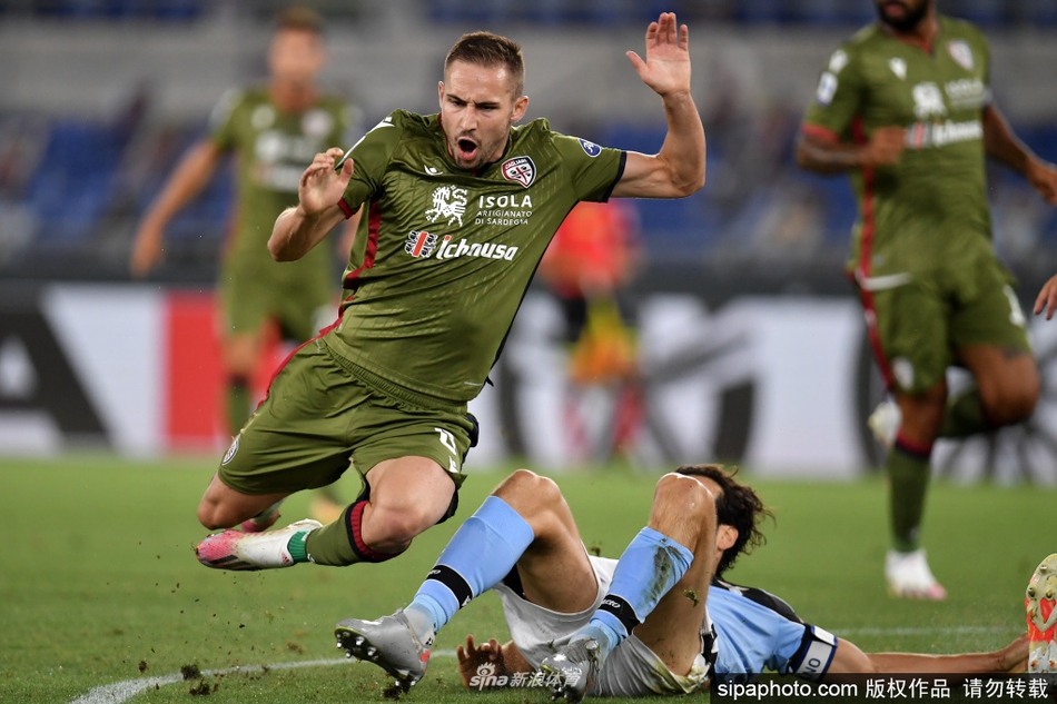 这是赛后的荣耀时刻，队长因莫比莱与队友米林科维奇高举双臂向看台上的球迷致谢。尽管受疫情影响无法与球迷近距离接触，但那份跨越看台的连接却无比坚实。背景的灯光映照在他们身上，仿佛镀上了一层金色的光辉，宣告着拉齐奥正式锁定了下赛季的欧冠联赛资格，一段长达十三年的漫长等待终于在今夜画上了圆满的句号。