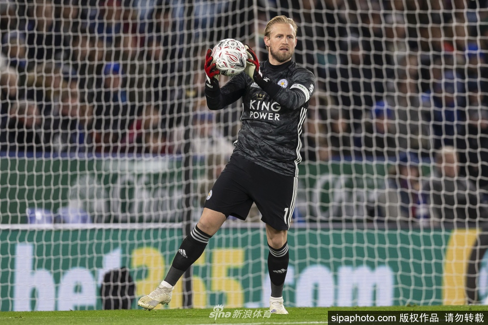 小舒梅切尔手捧丹麦足球先生奖杯，目光坚定地望向远方，身后的背景虚化，凸显出他此刻的荣耀与自豪。