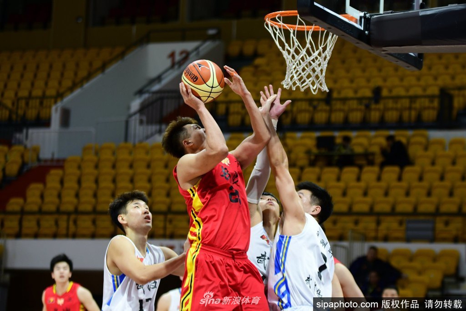 湖南金健米业队球员在三人包夹的严密防守下强行突破，他紧咬牙关，眼神坚定，用强壮的身体护住篮球，试图撕裂武汉队的防线。