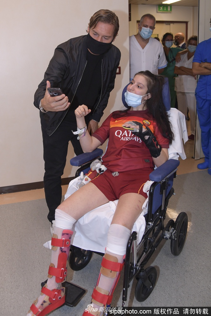 在医院的病房里，刚刚苏醒过来的伊莱妮娅终于见到了她日思夜想的偶像。她坐在病床上，用尽全力探出身子与托蒂拥抱。托蒂则温柔地俯下身，轻轻扶着她的肩膀，这个跨越了生死的拥抱，让在场的所有人无不为之动容。