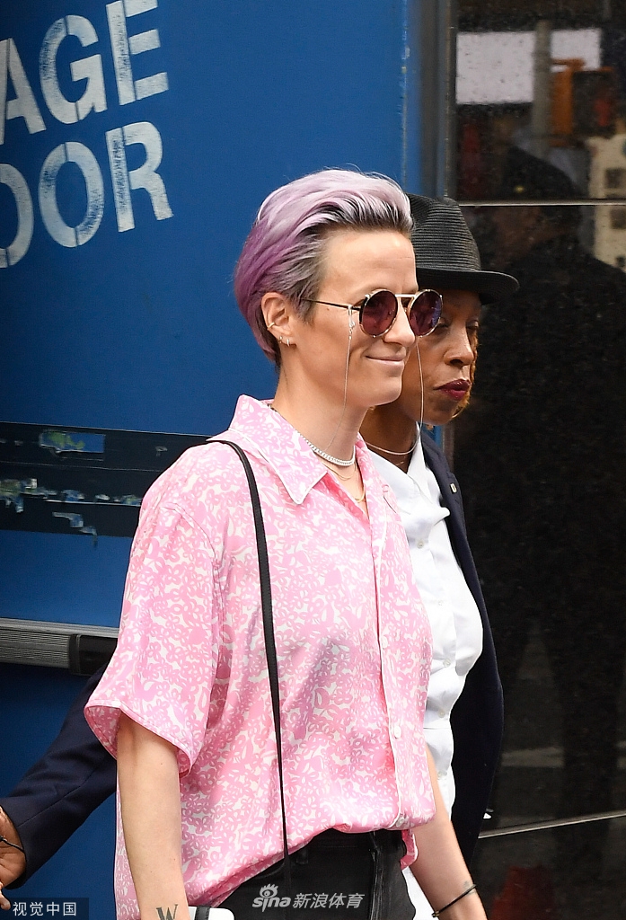 在电视台的后台走廊，拉皮诺埃随意地倚靠在墙边。她穿着一件宽松的字母印花卫衣，搭配简洁的牛仔裤，双手插兜，眼神坚定地望向前方。这个看似不经意的瞬间，却定格了她夺冠归国后的自信与松弛。