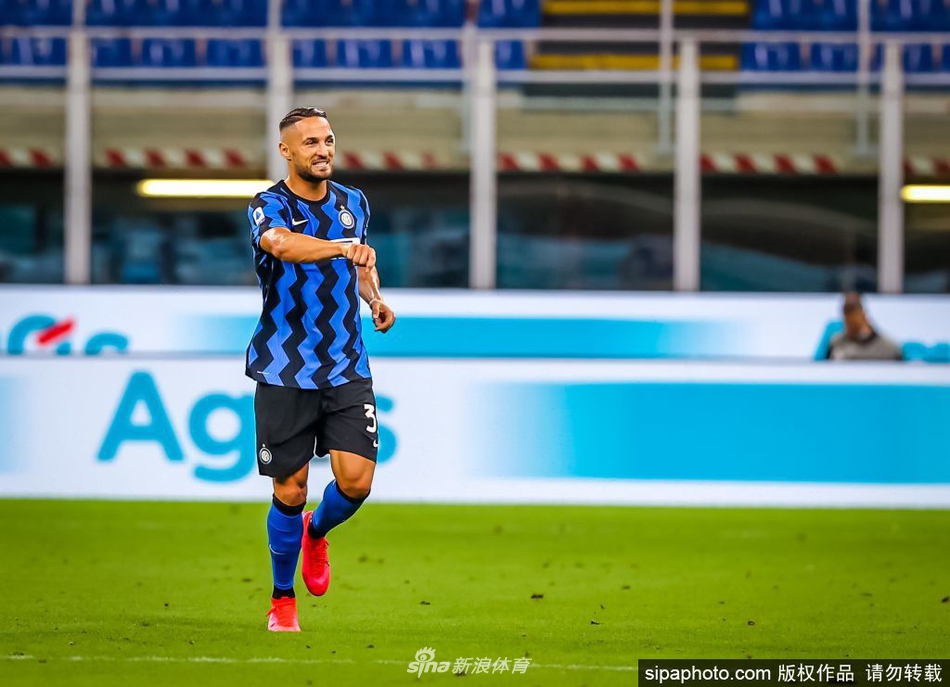 丹布罗西奥双手叉腰站在场上，阳光勾勒出他壮硕的肌肉线条，仿佛一尊沉默的守护神，短暂休憩只为下一次奋不顾身的拼抢