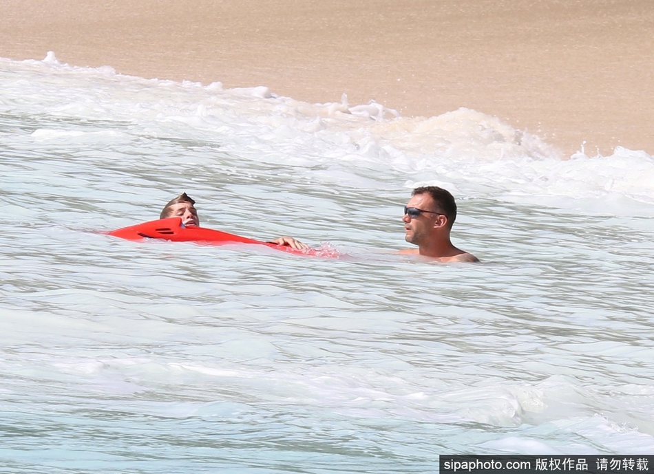 舍甫琴科的大儿子已经长成了帅气小伙，父子俩在沙滩上并肩而行，背影如同两座挺拔的山峰，仿佛诉说着足球基因与父爱的传承。