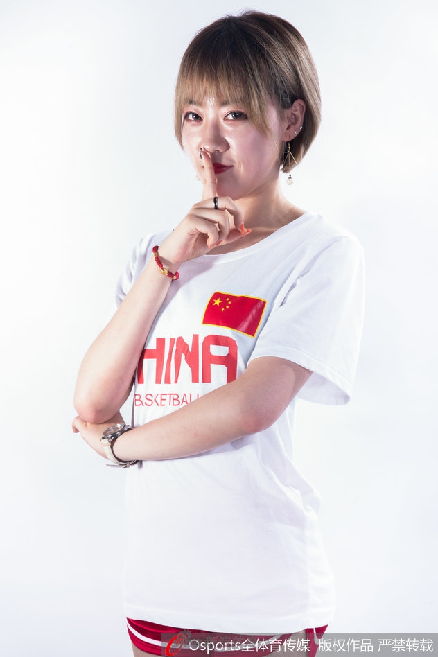 镜头特写，一位宝贝手举红色加油花球，遮住半边脸颊，更显俏皮可爱