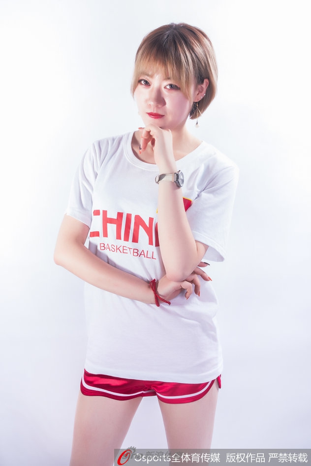 篮球宝贝身穿白色中国队T恤，对着镜头露出甜美自信的微笑，活力四射