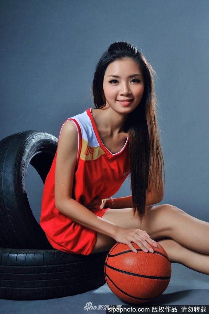 钟苑庄侧身站立,双手抱球高举过头,身体曲线在球场光线下显得健美而修长