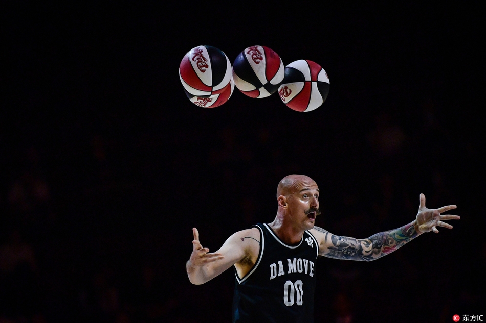 表演者正与场边小观众进行亲密互动,他将篮球轻轻递出,眼神中充满鼓励,孩子们脸上洋溢着惊喜的笑容,现场气氛温馨而热烈。