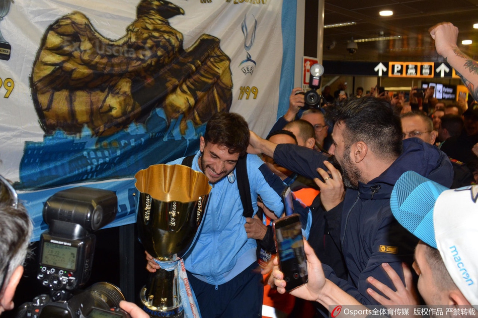 冠军凯旋，拉齐奥球员们在机场出口高举着象征荣耀的意大利超级杯冠军奖杯，与等候多时的蓝鹰死忠们共同分享这一历史性的喜悦时刻。
