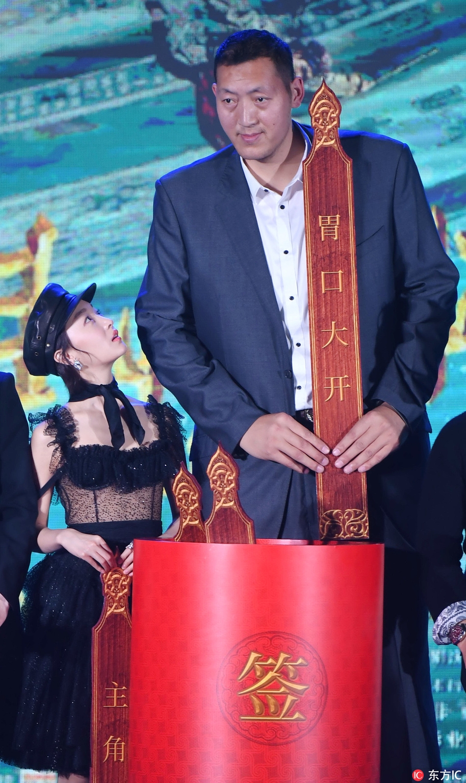 孙明明在签名板前驻足留影，身着简约服饰却难掩磅礴气势，镜头仰视之下更显其巍峨，一举一动都散发着从体育健将到银幕新星的从容转变。