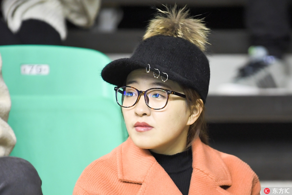 赛后，一位笑靥如花的女球迷举起手中的围巾向赛场挥舞，眼神中充满了对主队获胜的自豪与喜悦。