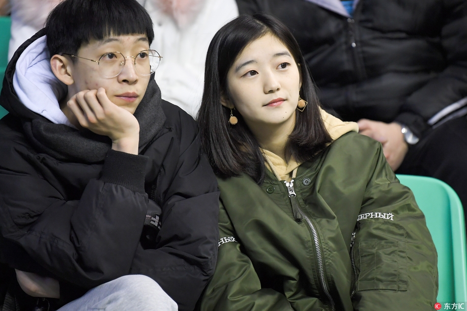 几名青春靓丽的女球迷在看台上合影留念，她们身后的电子大屏幕还显示着辽宁队获胜的比分，记录下了这美好的瞬间。