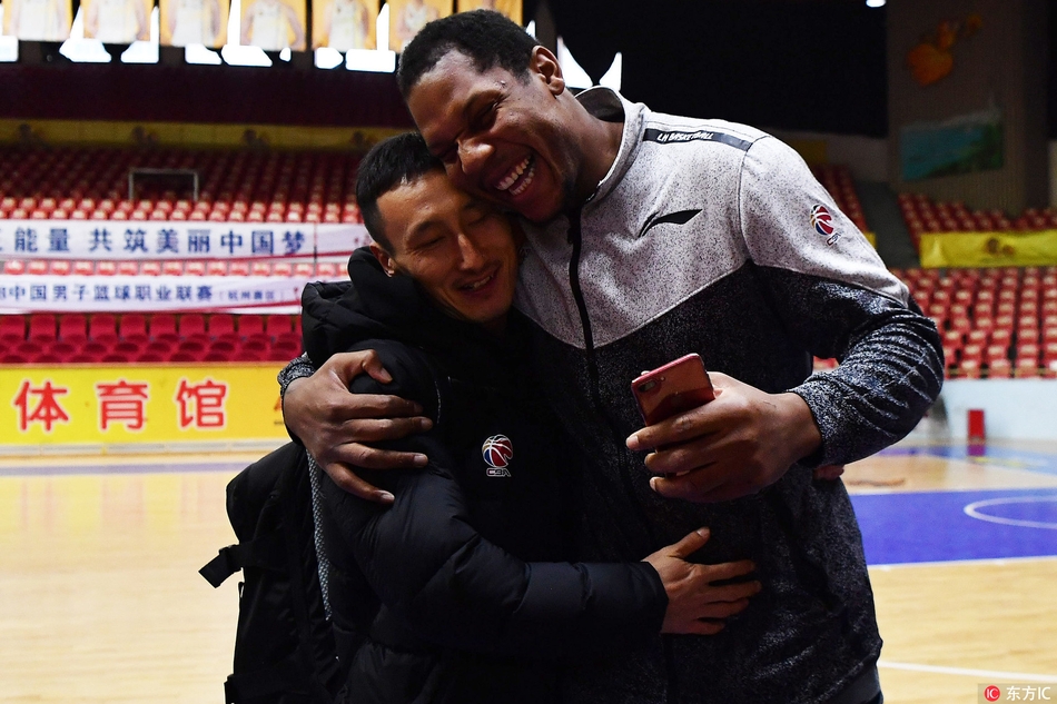 霍尔曼蹲下身与昔日队友的小孩玩耍,巨大的身躯与小孩子的稚嫩形成鲜明对比,画面温馨有爱