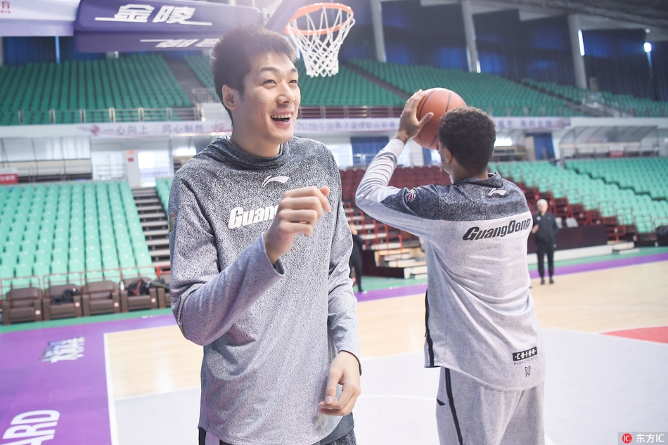 易建联篮下强起,肌肉线条绷紧,防守球员高举双臂形成遮天蔽日的干扰