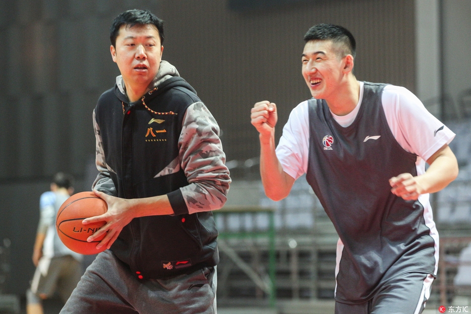 王治郅在一群年轻球员中间格外显眼，他正在用双手比划着，讲解高位策应的战术跑位。