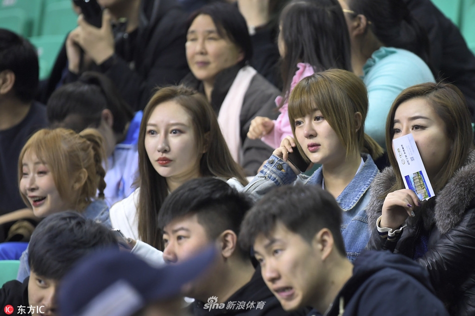 一位气质文静的女球迷双手托腮坐在看台上，眼神中带着一丝对比赛结果的担忧，楚楚动人的模样惹人怜爱。