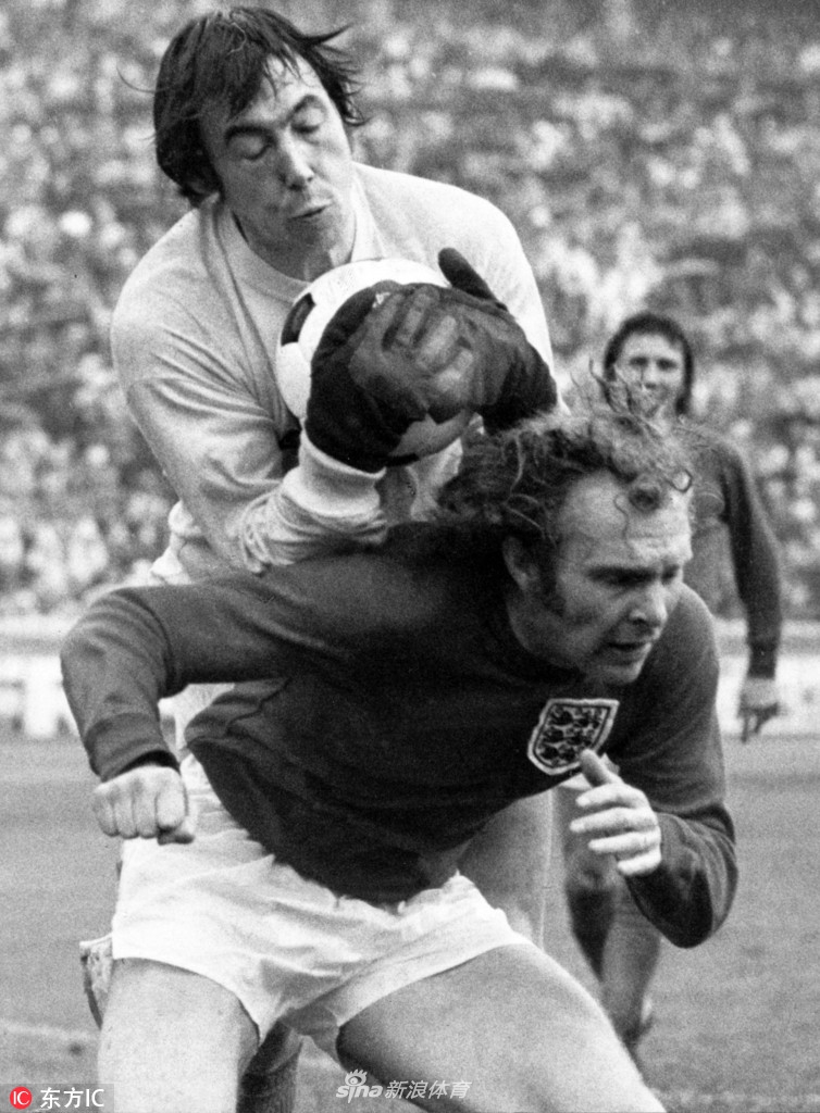 身披斯托克城条纹球衣的班克斯，在比赛中奋力跃起，双手稳稳摘下高空球。他的表情坚毅，双臂肌肉线条分明，展现出那个时代门将依靠扎实基本功和强悍身体素质的典型风格。